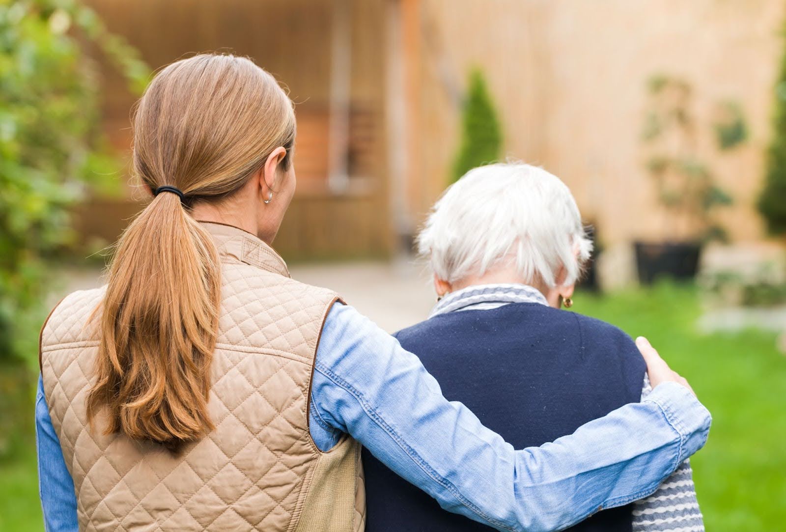 Woman with her arm around a senior woman walking