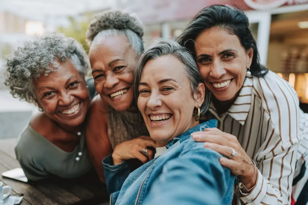 A group of seniors hugging while taking a selfie at Sagewood, in Phoenix, AZ.