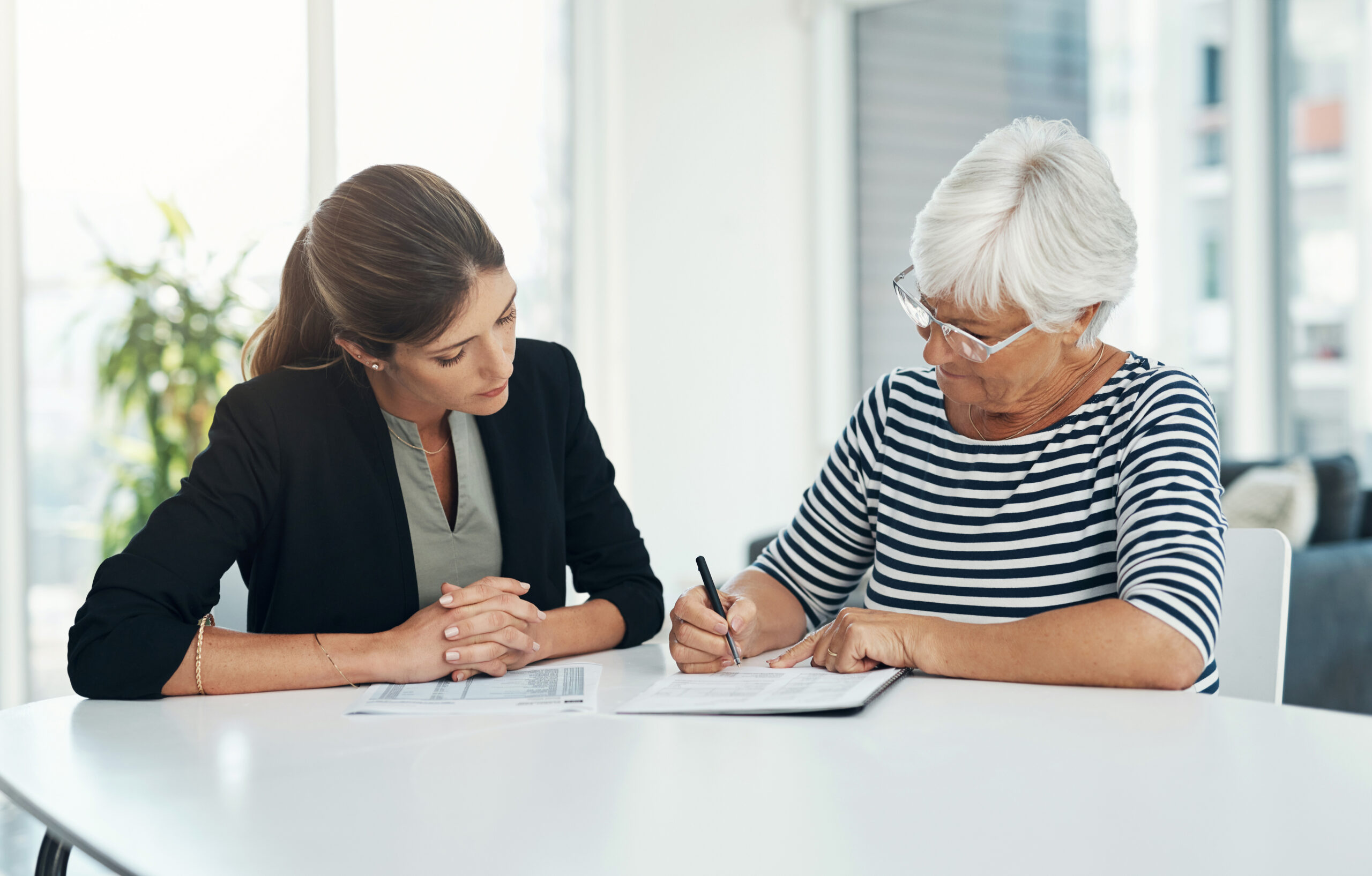 Advisor, senior woman and signing contract for insurance, savings or retirement plan. Elderly client and a banker, broker or finance consultant person with a document for agreement and signature